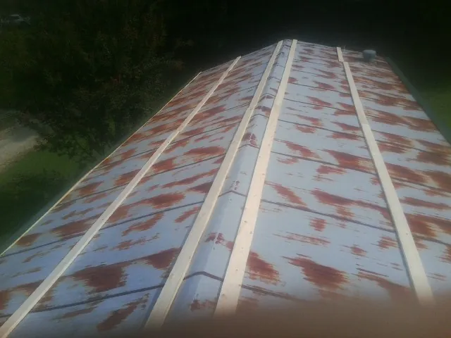 Rusted metal roof panels with new wood purlins before replacement — Storm Damage Roof Repair in Green Cove Springs by Roofing Brothers