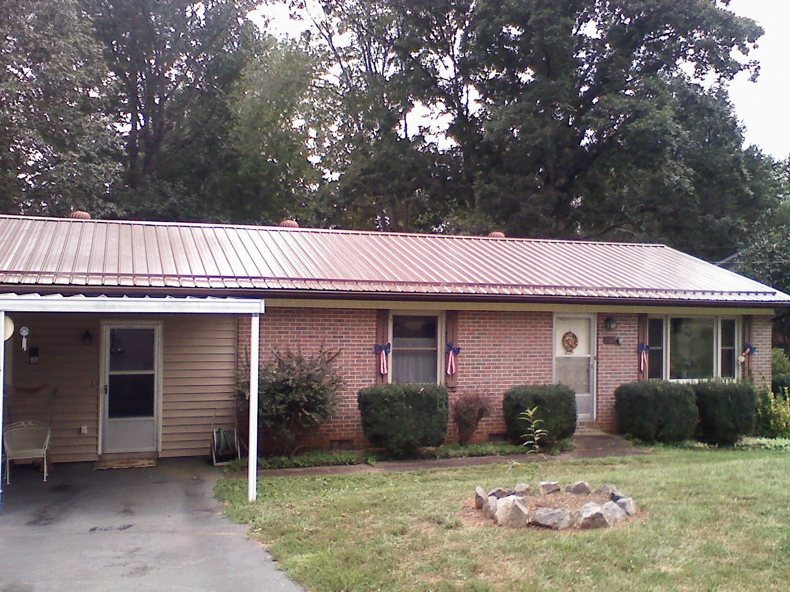 Bronze metal roof and carport on a brick ranch home — Roof Repair work by our crew in Green Cove Springs